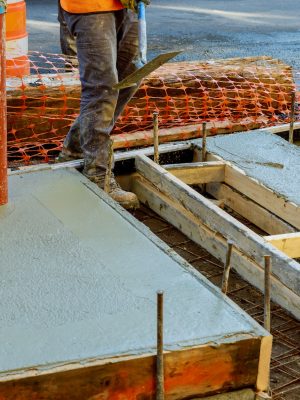 Concrete construction Tampa. a Construction worker leveling concrete pavement